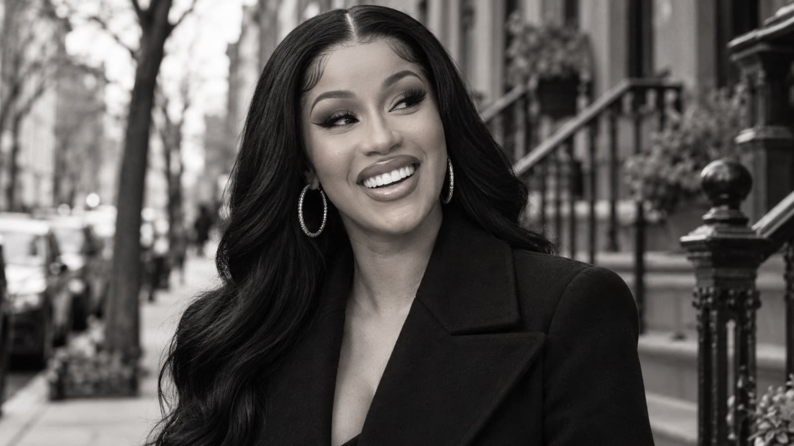 Black-and-white portrait of a smiling woman outdoors.